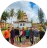 Circular profile image of a group of people standing in front of a colorful temple-like structure outdoors.